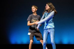 A girl and boy stand on stage