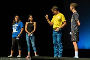 Three campers talk on stage with camp director