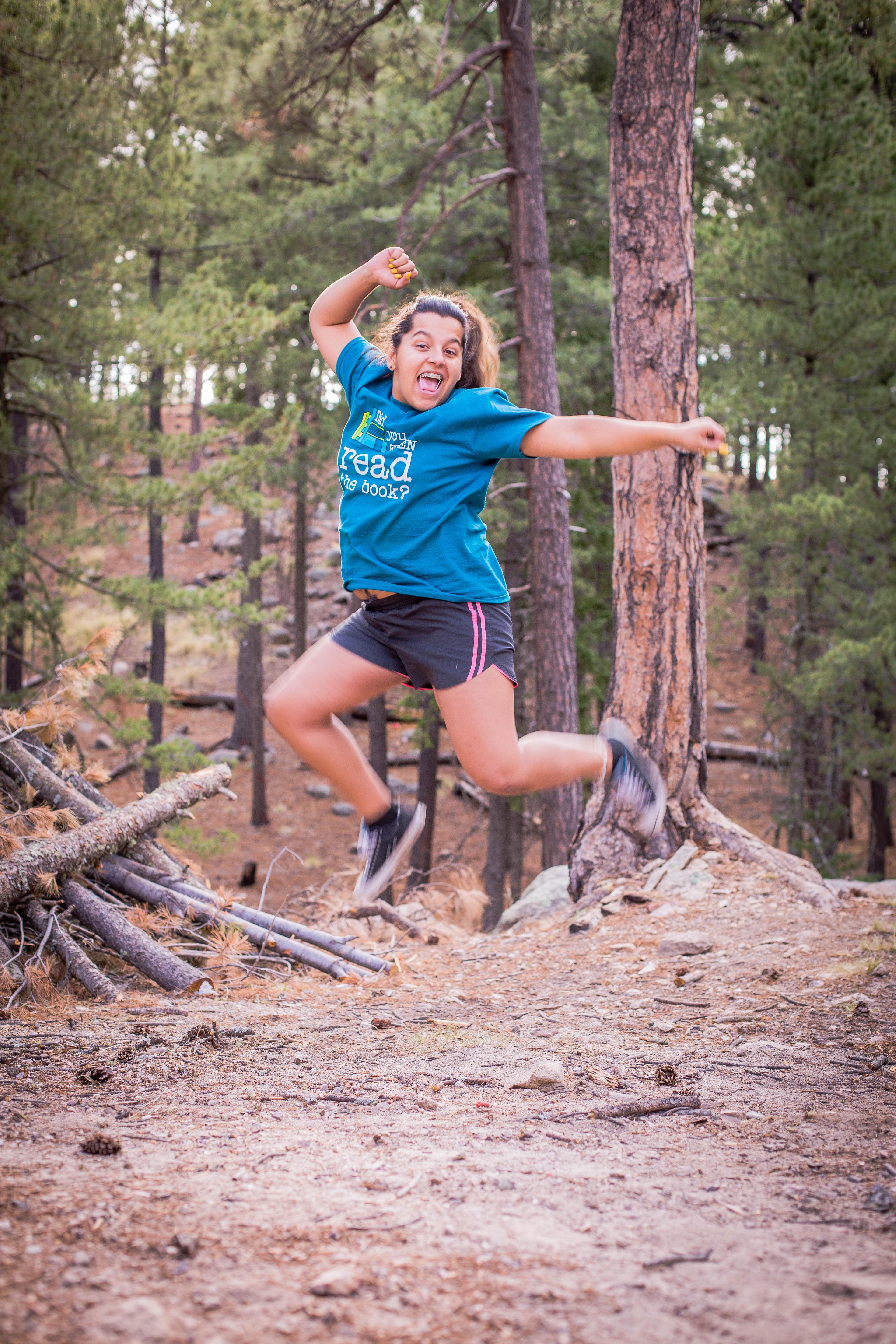Girl jumps happily in the woods