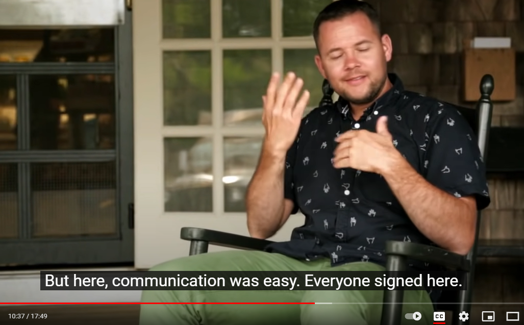 Video still on a man sitting outside using ASL