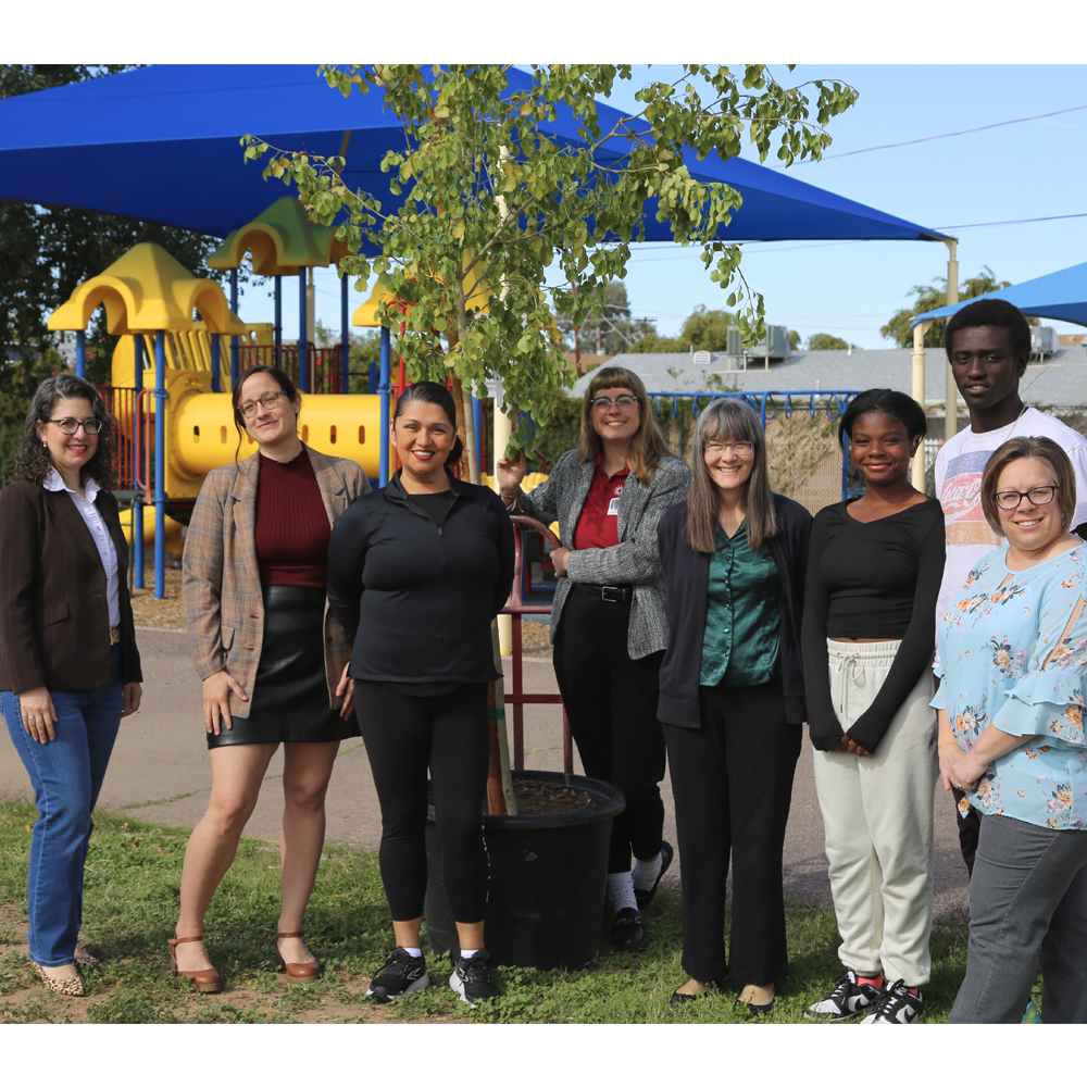 From left to right, Maria Murphy, Shelley Beaudean, Councilwoman Betty Guardado, Kayla Killoren, Annette Reichman, Miracle Phillips, Kotu Salih, PDSD Principal, Jill Voit. standing next to the first tree to be planted.