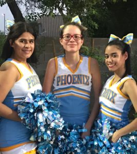 three cheerleaders pose