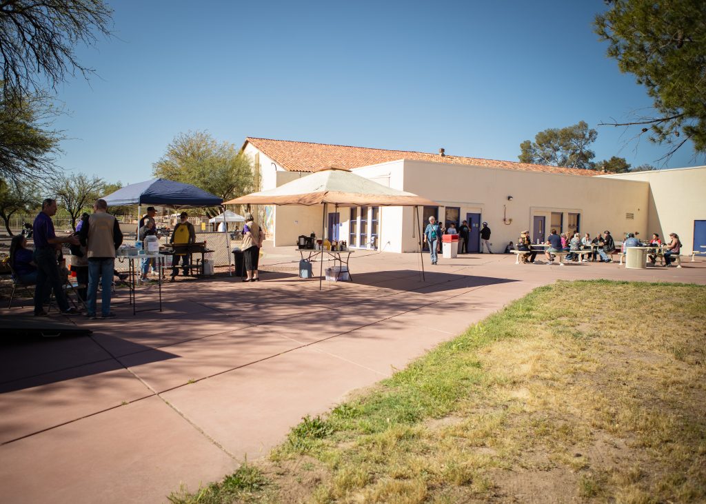 a photo showing two pop-up tents providing shade to the Oro Valley Lion's club as they pass out pancakes