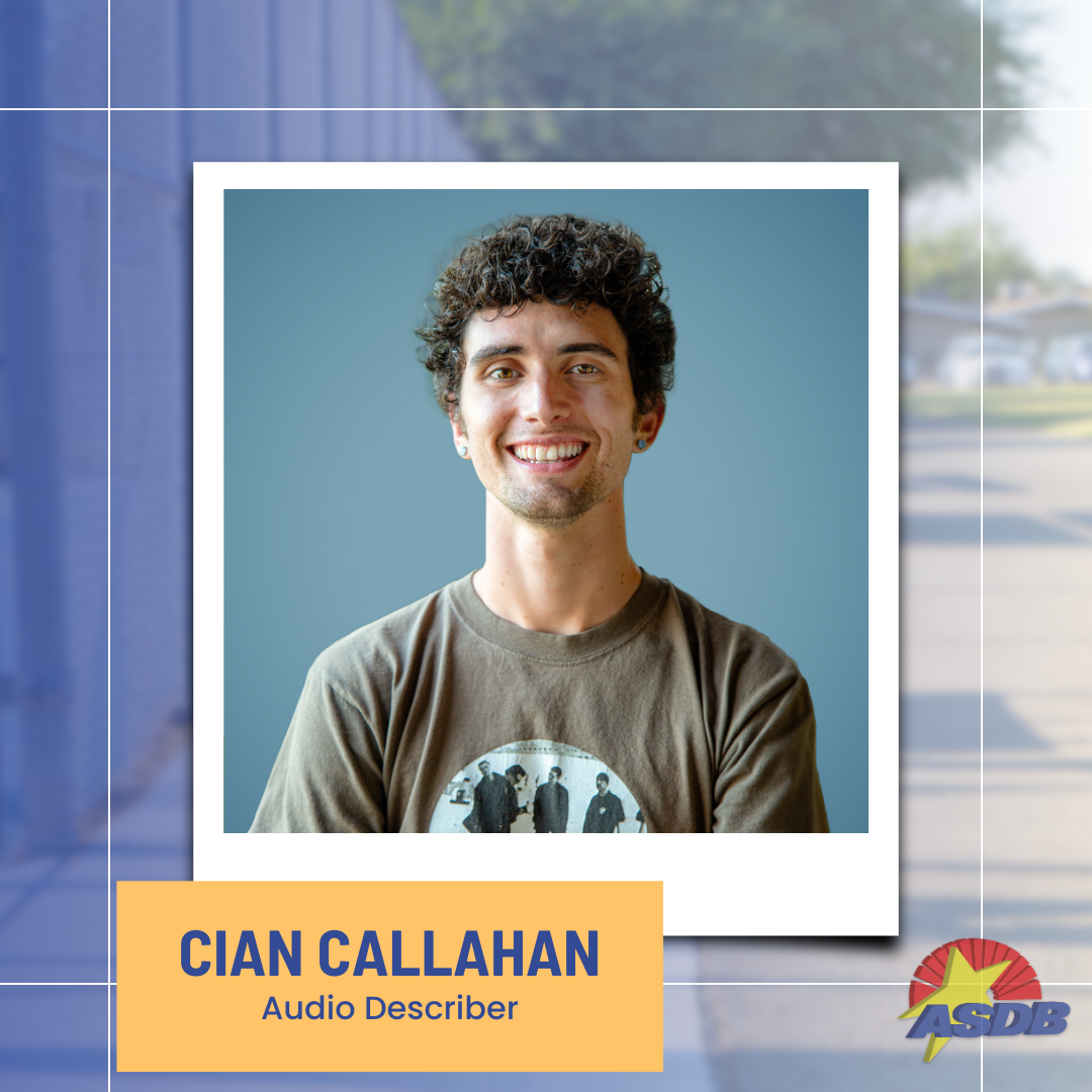 A portrait photo of Audio Describer Cian Callahan. Cian has short curly hair and is wearing an army green t-shirt displaying the band, U2.